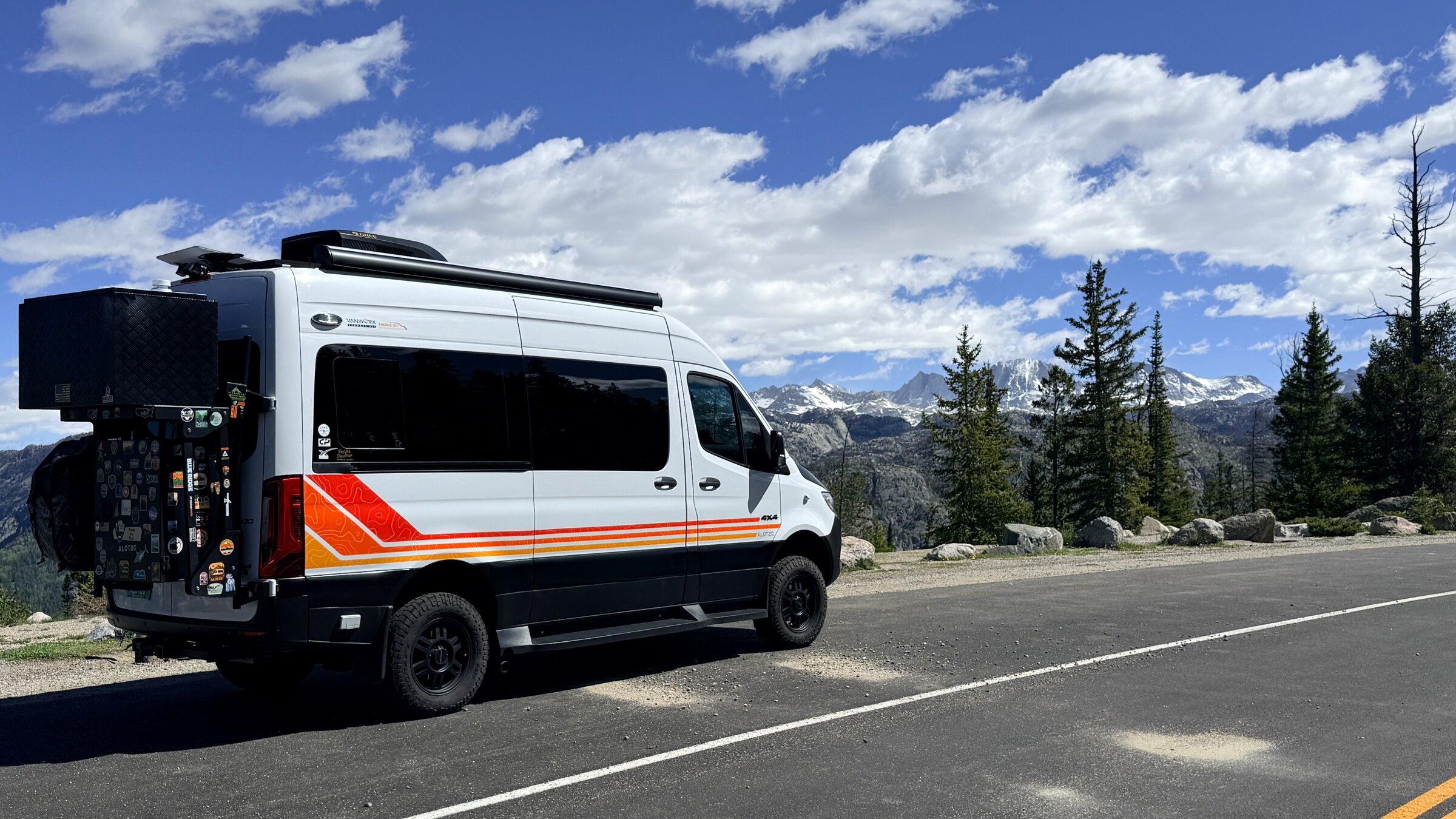 Custom Mercedes-Benz Sprinter 4x4 overland van with retro livery in the mountains
